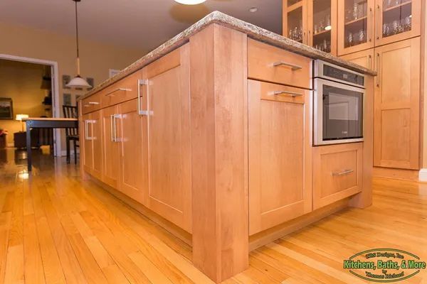A kitchen with wooden cabinets, granite counter tops, and stainless steel appliances.
