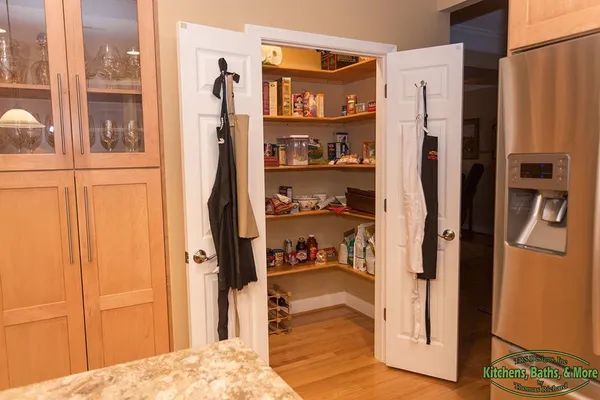 A kitchen with a pantry and a refrigerator.