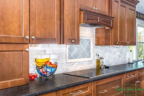 A kitchen with wooden cabinets and a black counter top.