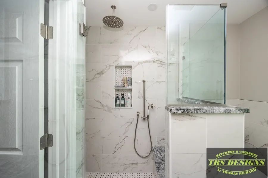 A bathroom with marble tiles and a walk in shower.