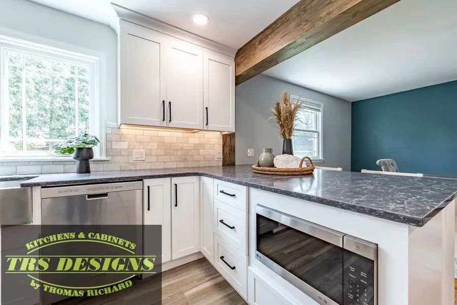 A kitchen with white cabinets, granite counter tops, and stainless steel appliances.