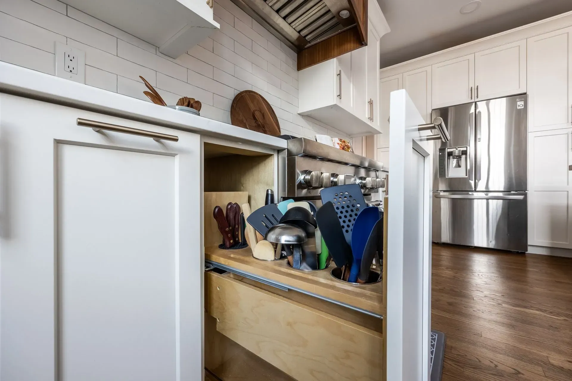 A kitchen with white cabinets and a stainless steel refrigerator.