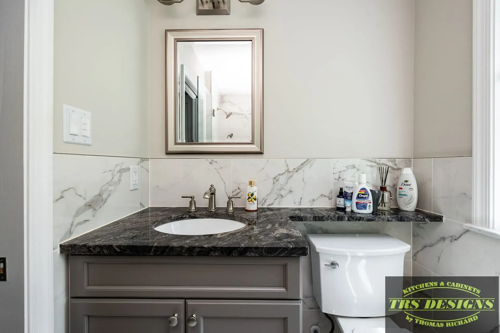 A bathroom with a sink , toilet and mirror.