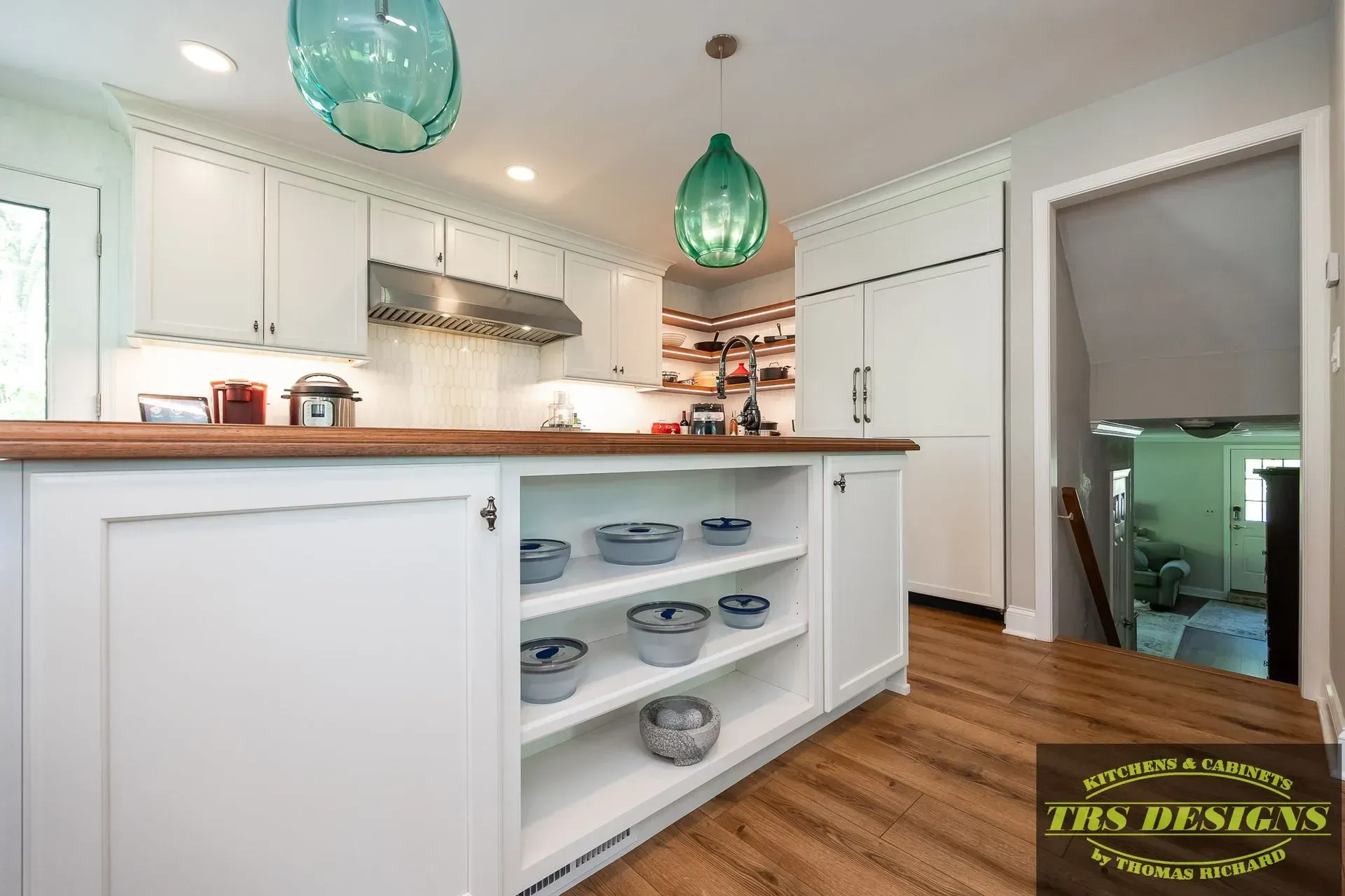 A kitchen with white cabinets and a wooden counter top.