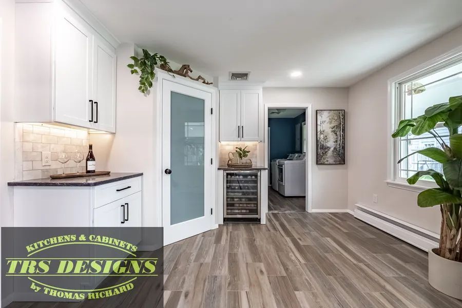 A living room with hardwood floors and white cabinets.