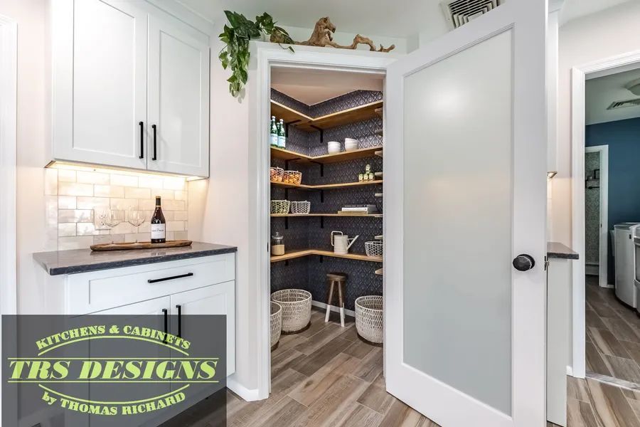A pantry with a glass door and shelves in a kitchen.