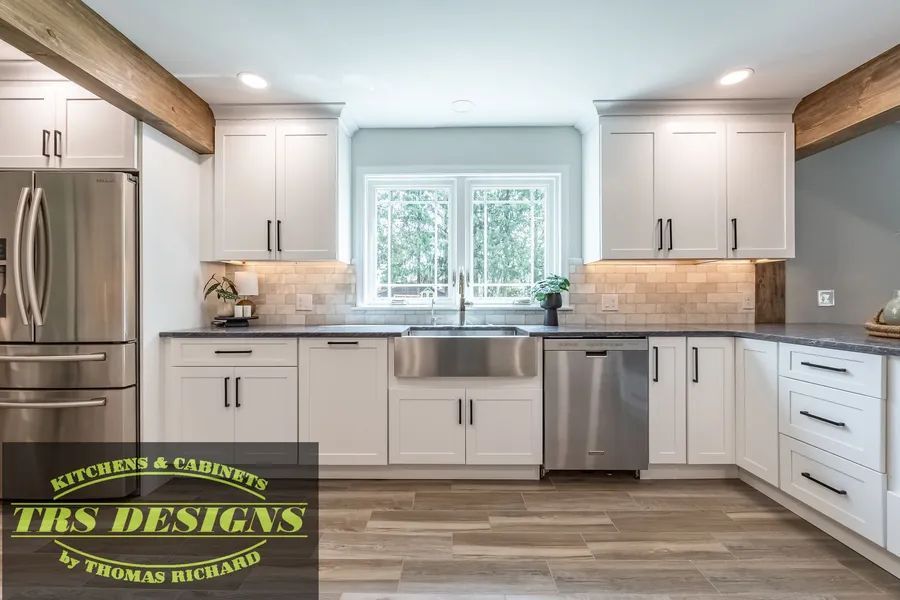 A kitchen with white cabinets and appliances.