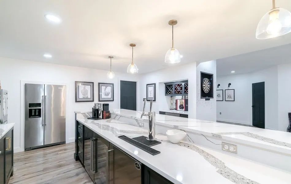 A kitchen with stainless steel appliances and white counter tops.