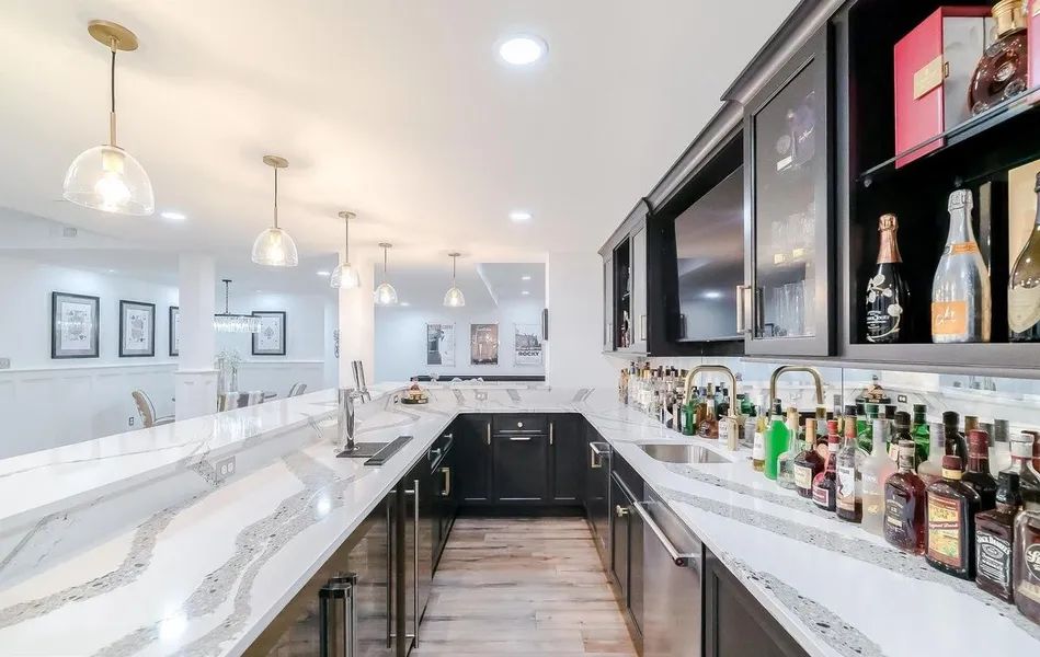 There are many bottles of alcohol on the shelves in the kitchen.