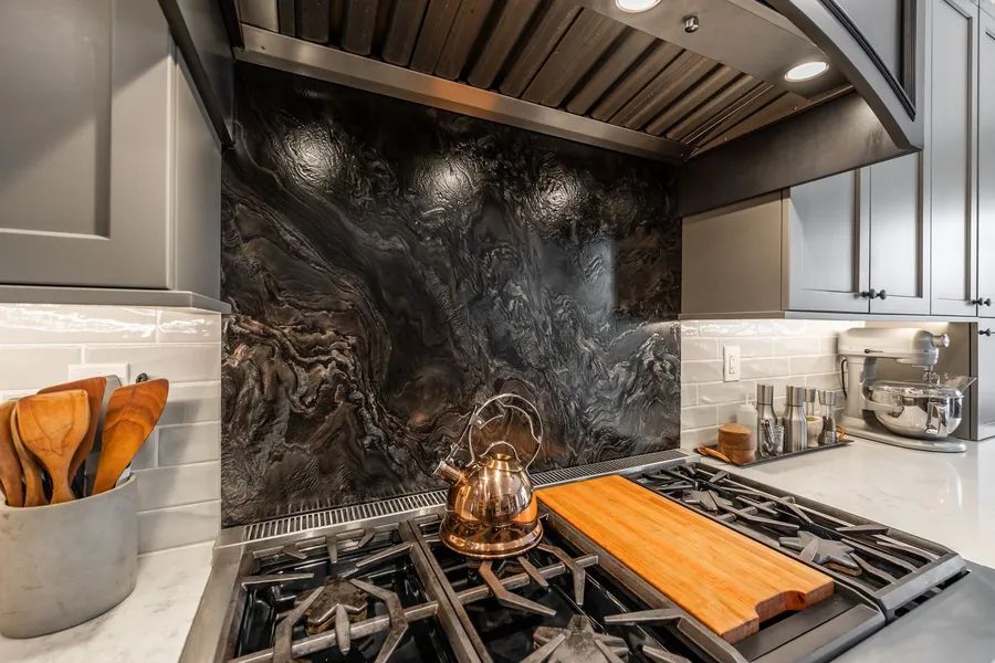 A kitchen with a stove top oven and a wooden cutting board.