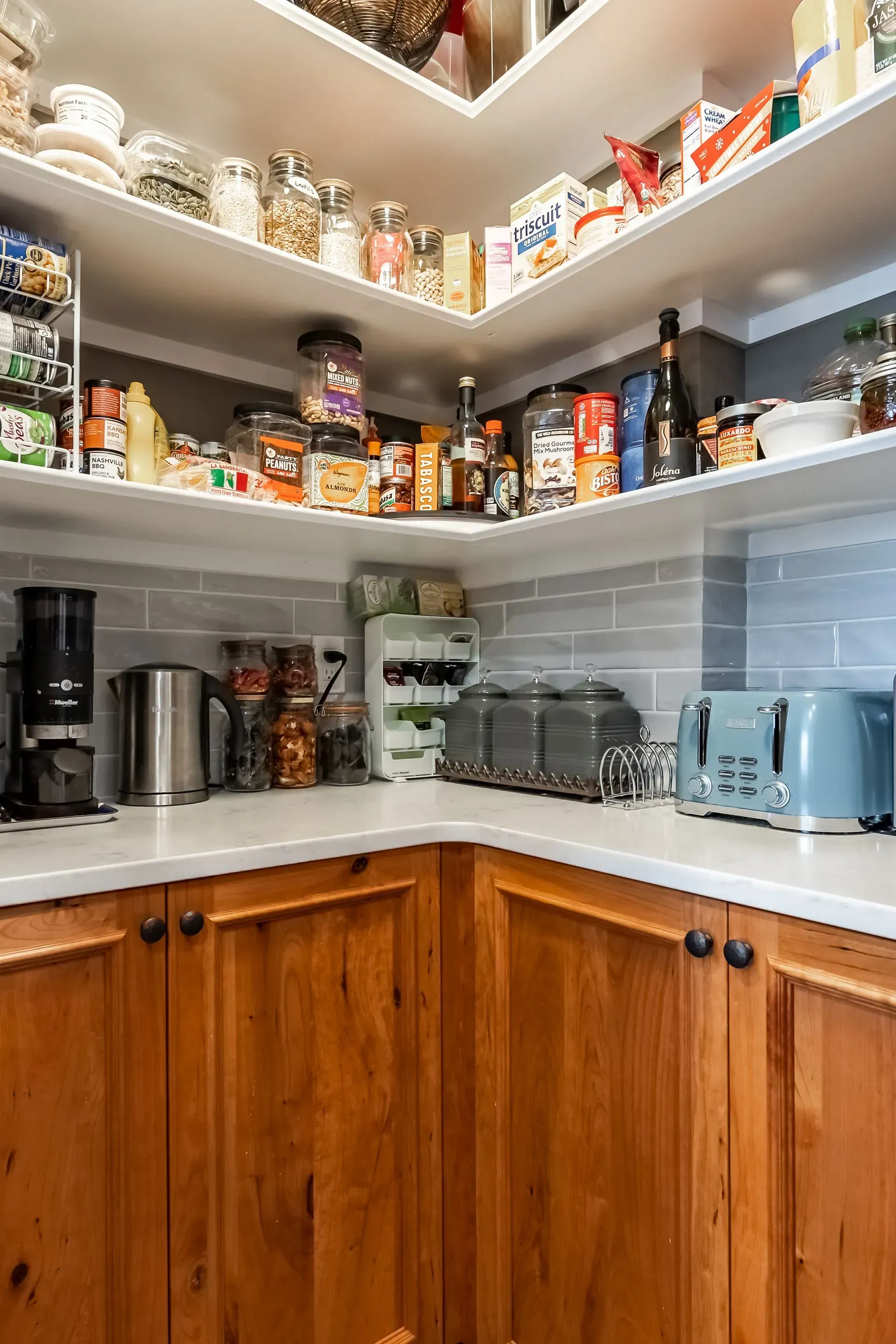 A kitchen pantry filled with lots of food and appliances.