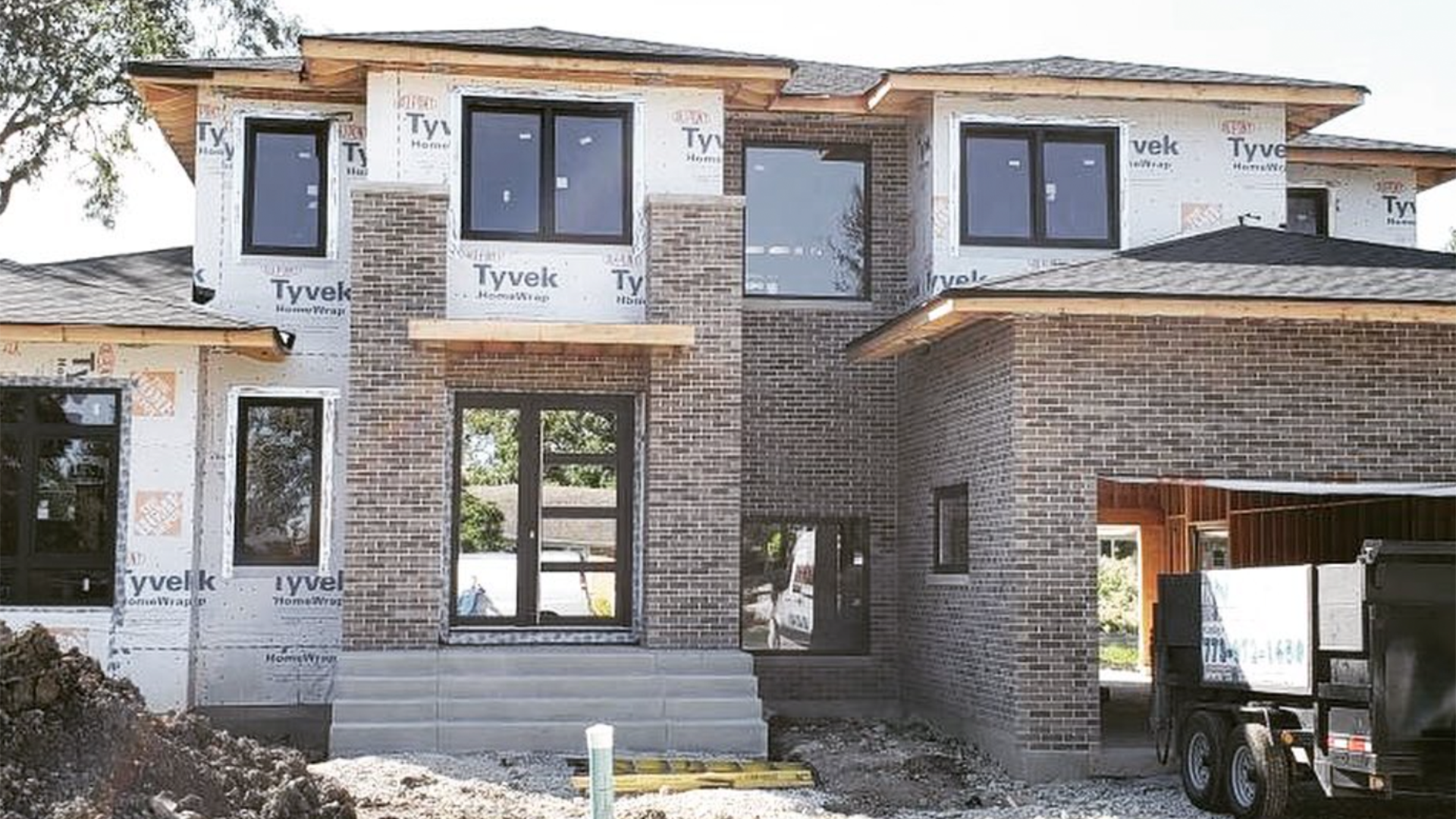 A large brick house is being built with a lot of windows.