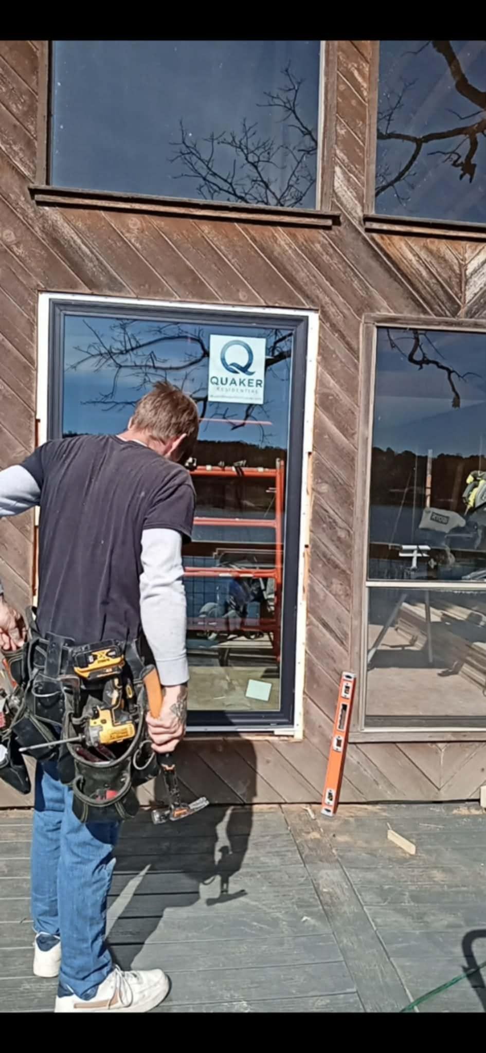 Window installation professional fitting a replacement window on the exterior of a building