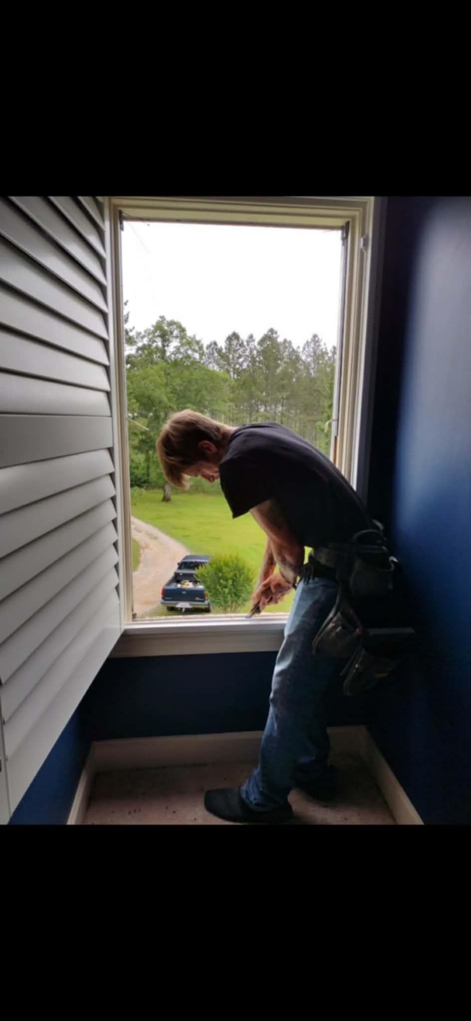 Window installation professional fitting a replacement window on the exterior of a building.