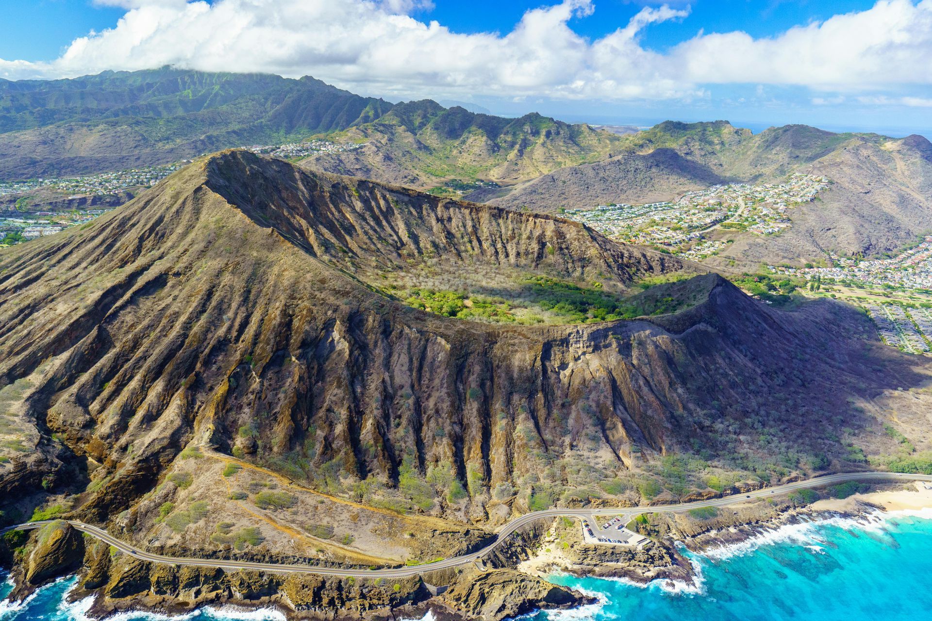 Diamond Head crater overlooking turquoise ocean, Oahu, Hawaii. Brown slopes and green vegetation.