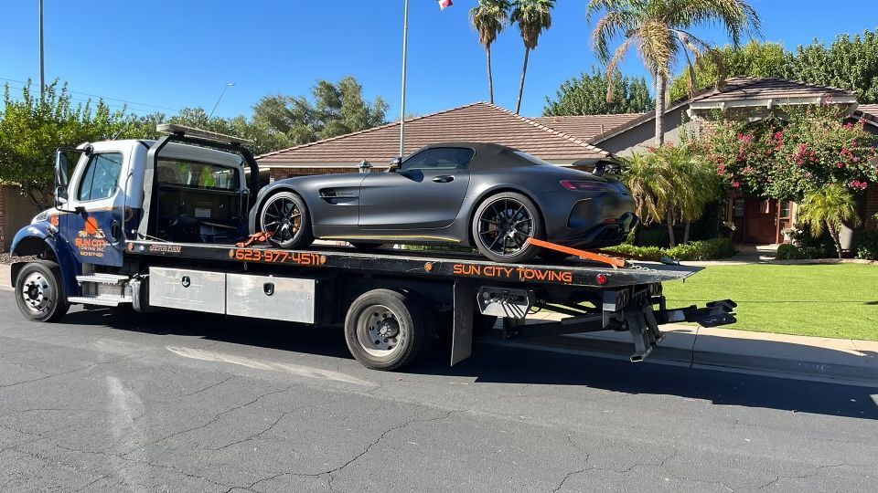 sun city tow truck towing a sports car black