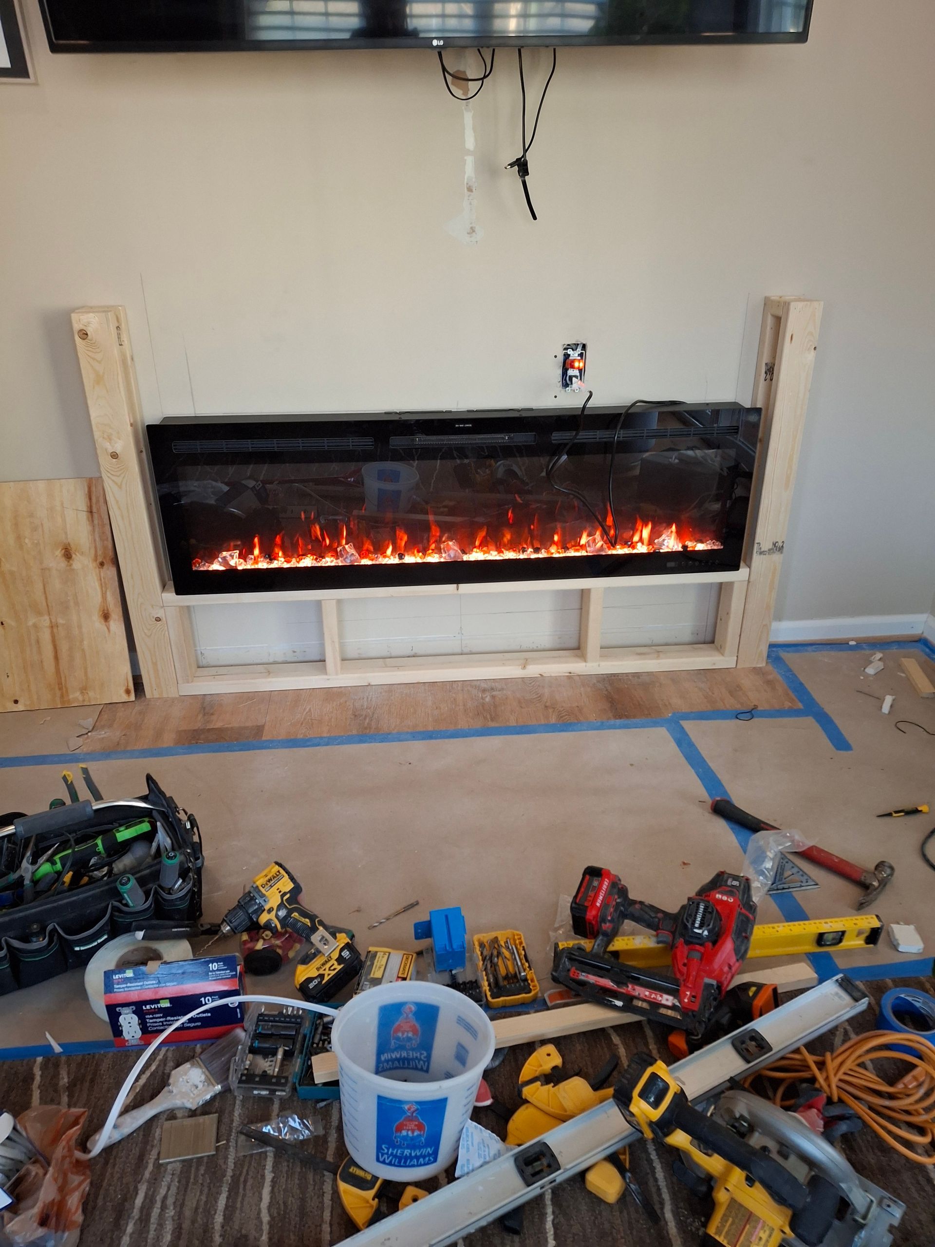 A fireplace is being built in a living room.