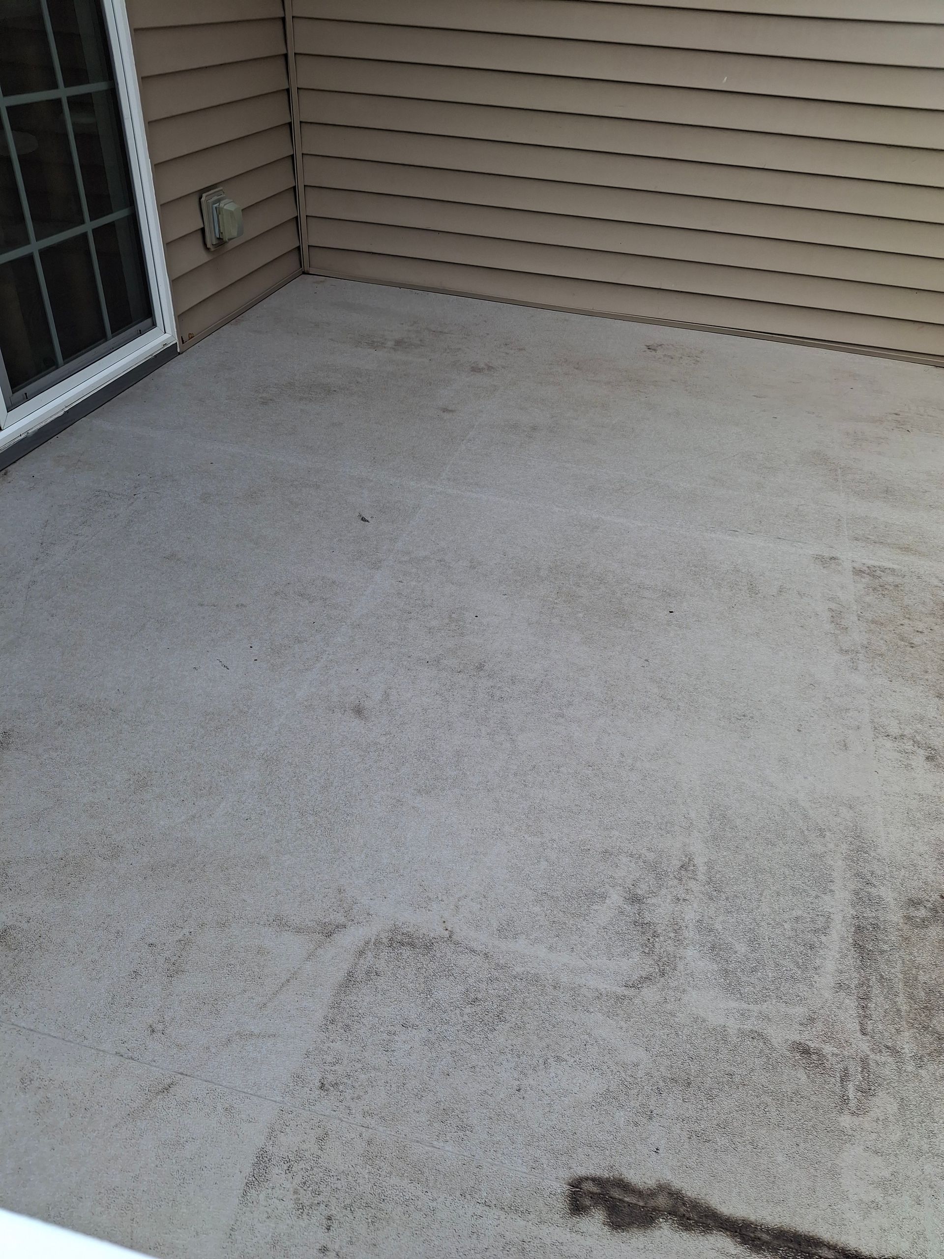 A patio with a window and a concrete floor