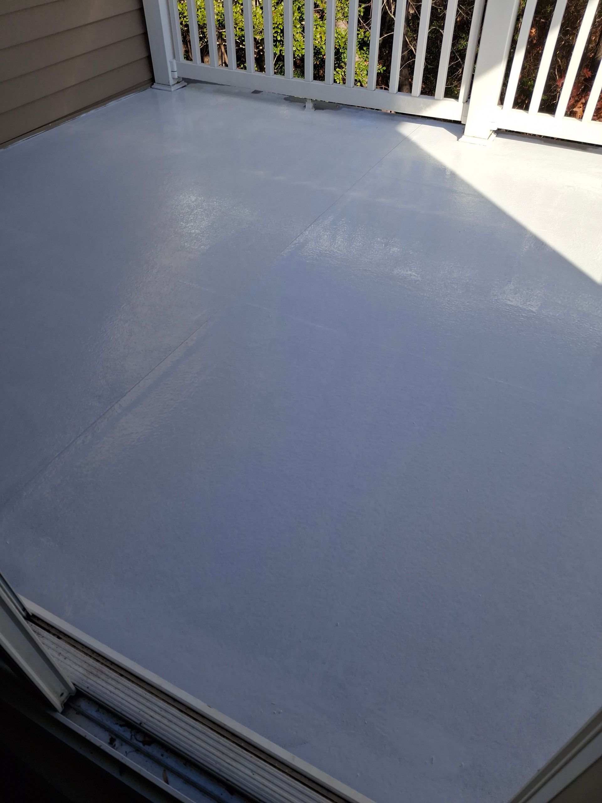 A white deck with a white railing and a white floor.