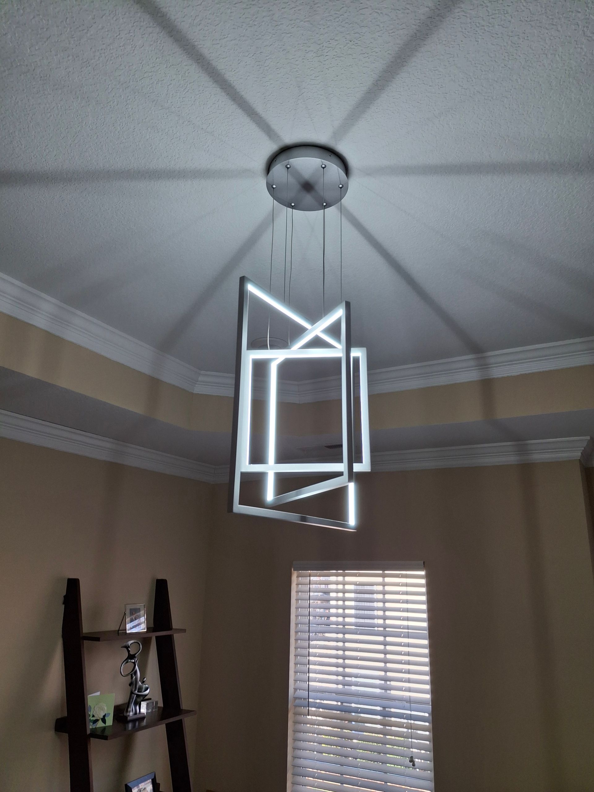 A light fixture is hanging from the ceiling in a living room.
