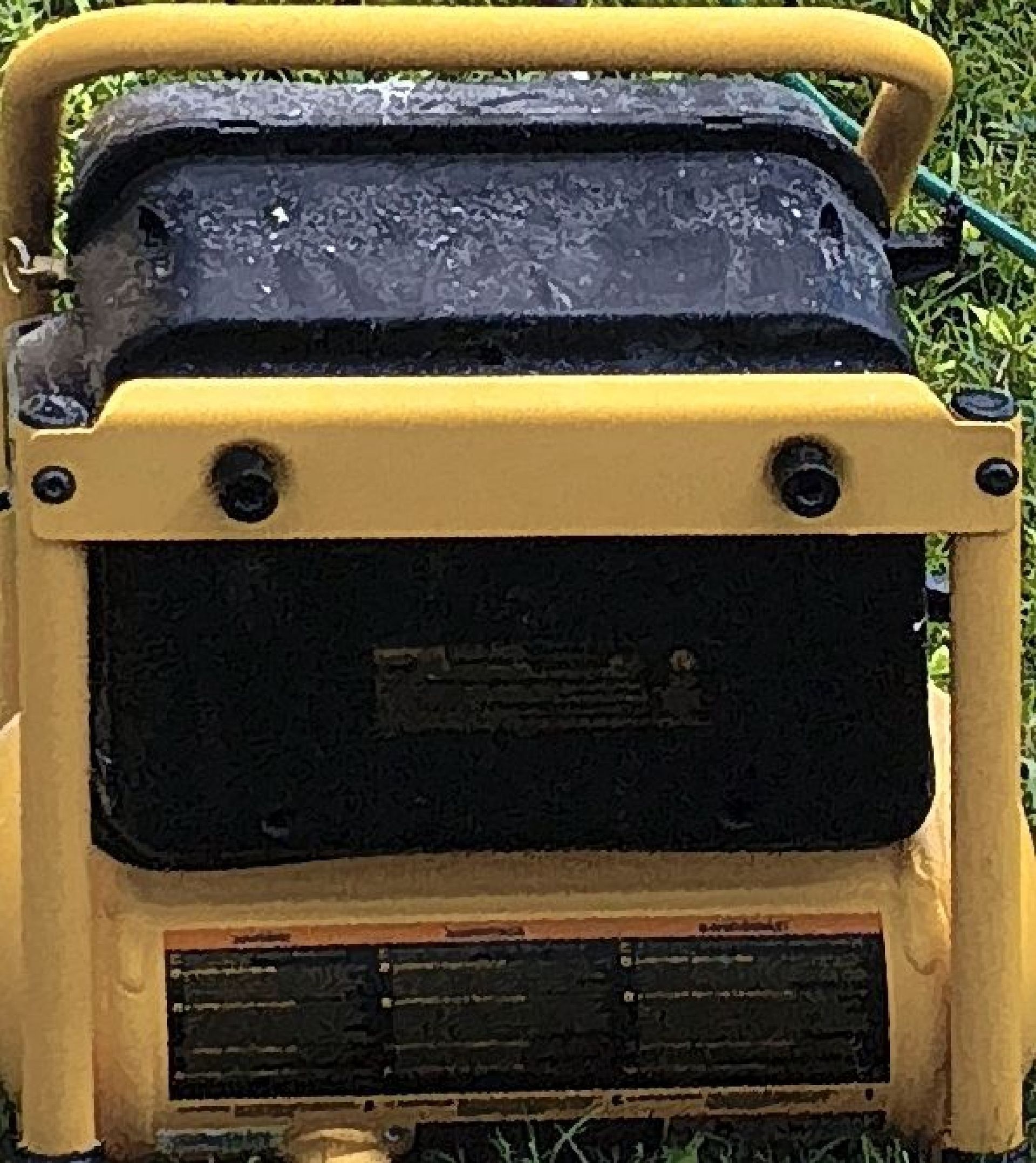 Yellow-framed black generator or machine outdoors, viewed from the front.
