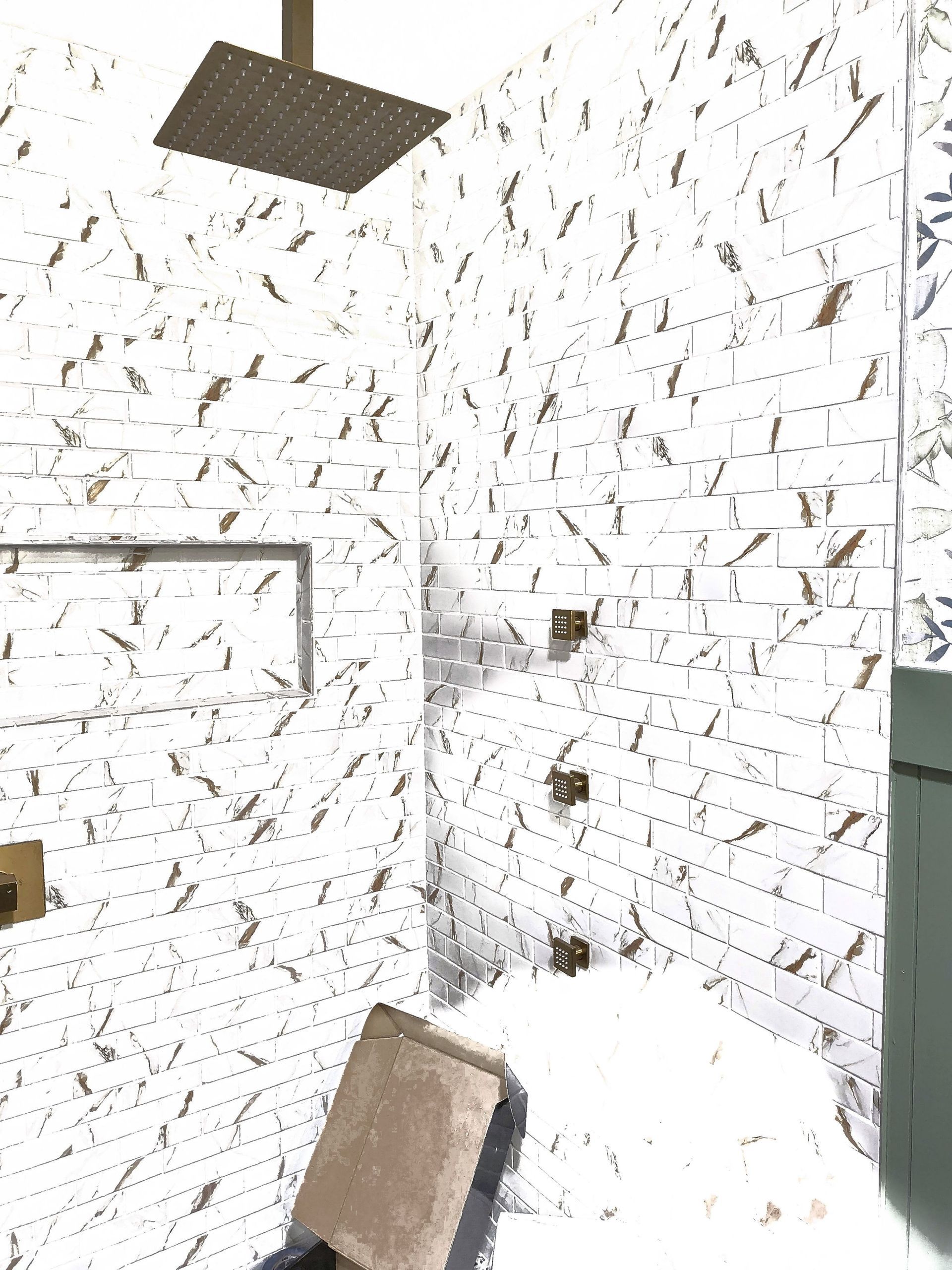 White brick wall with black scribble-like marks, a hanging dark panel, and a leaning board in the corner.