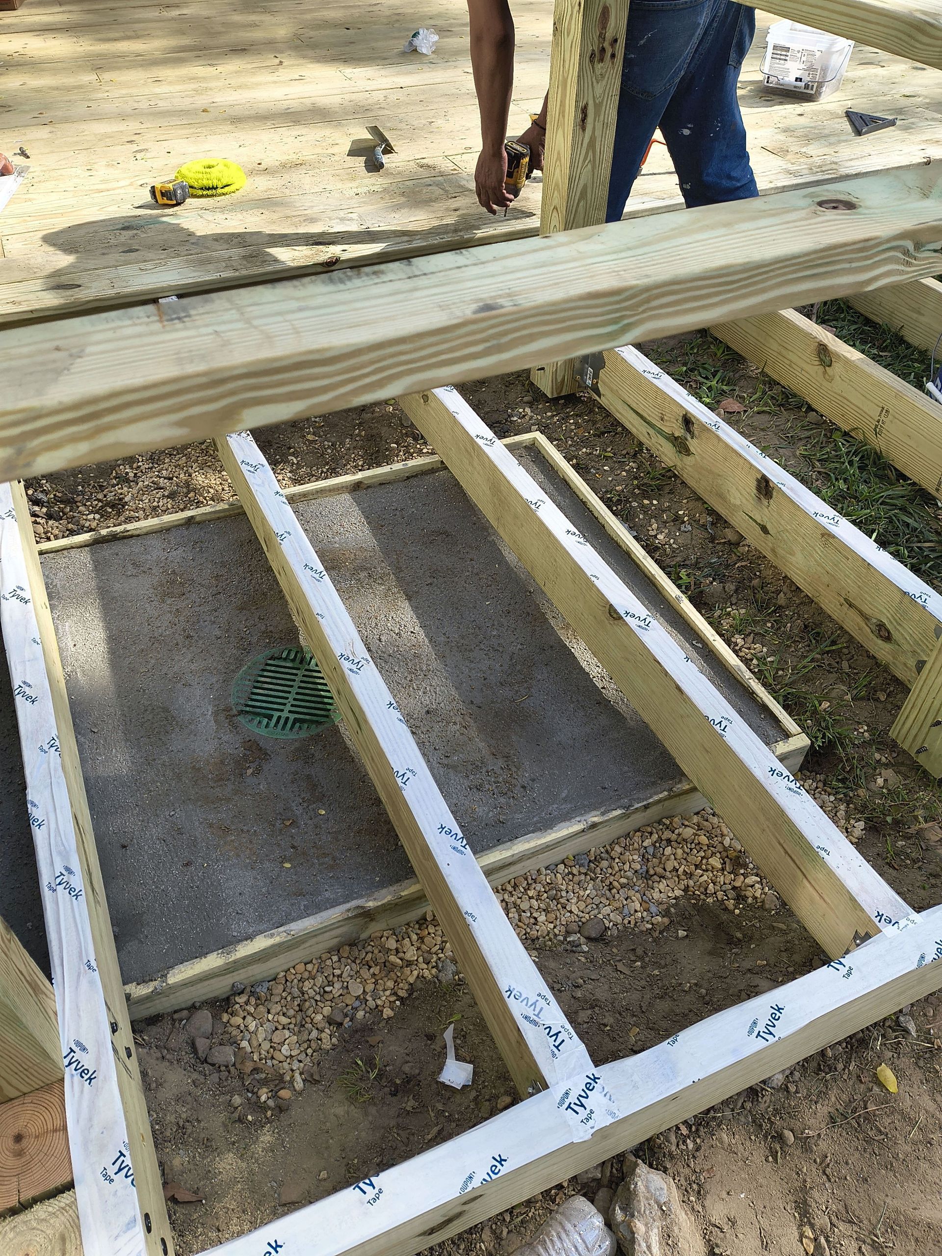 Construction site with a wooden frame and beams laid over a rectangular opening in the ground