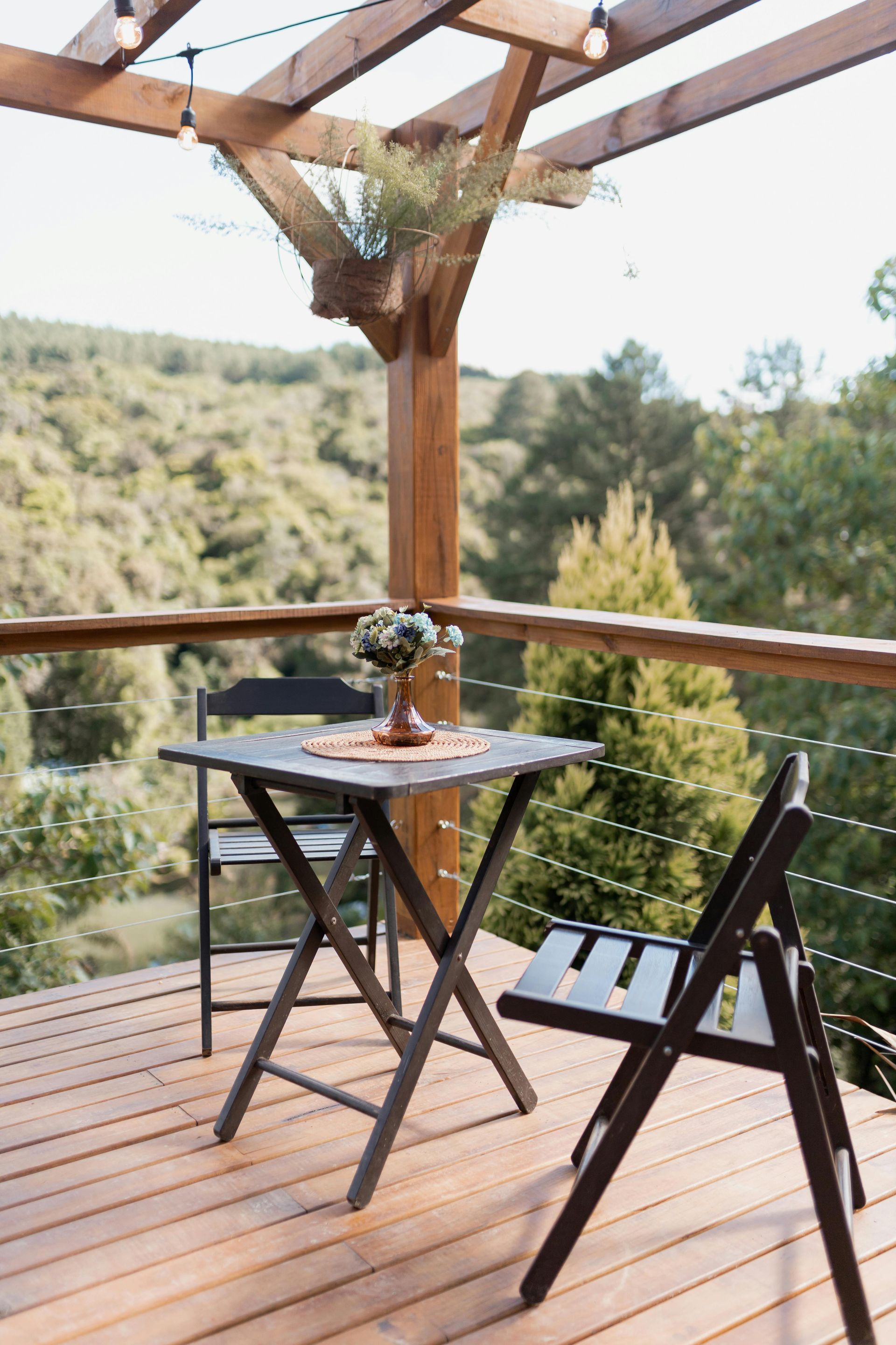 Wooden backyard deck with stairs beside a house and fenced yard