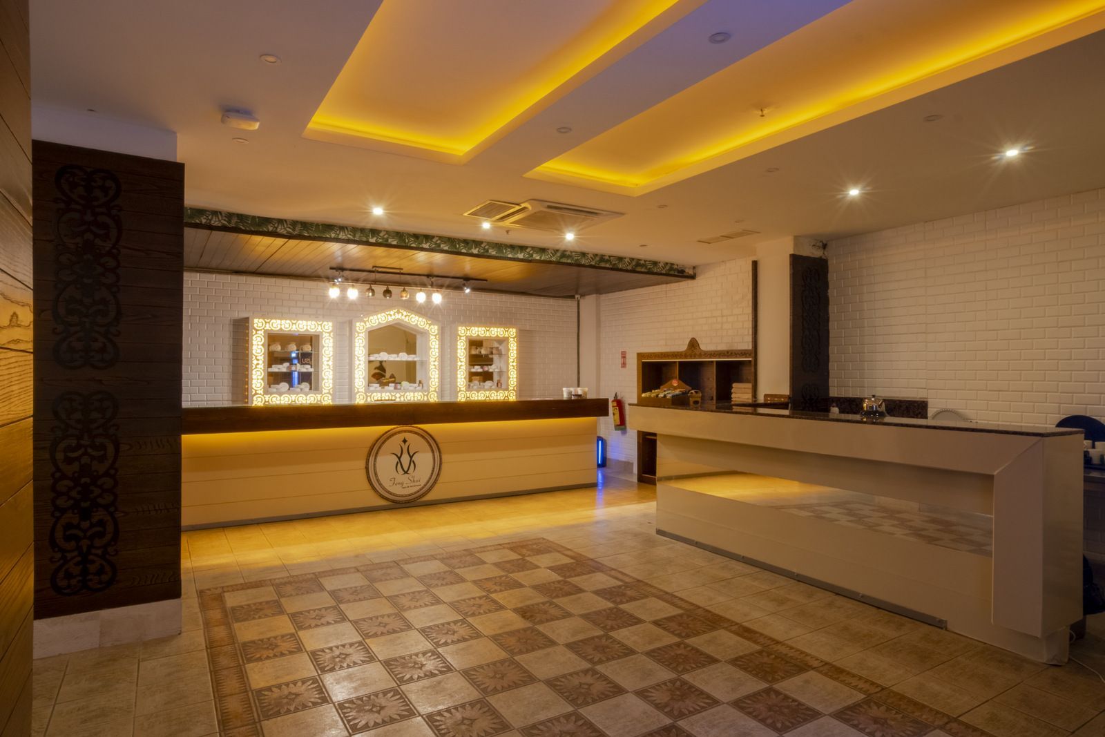 Damalı zemini ve duvarında saati olan bir otel lobisi.