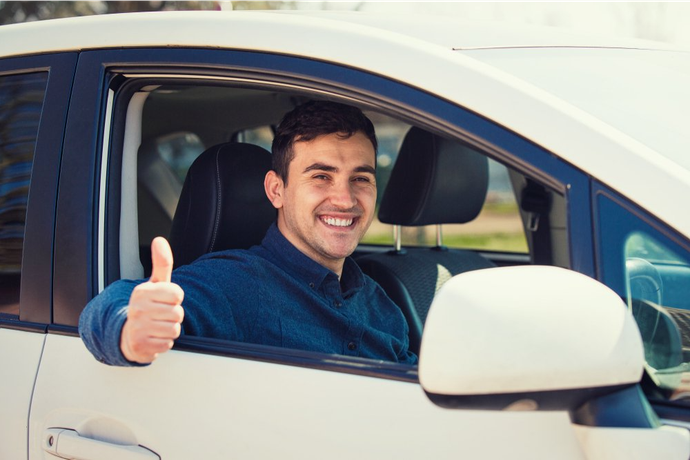 A Man Is Giving A Thumbs Up While Sitting In A Car — Auto Spares Morisset In Morisset, NSW