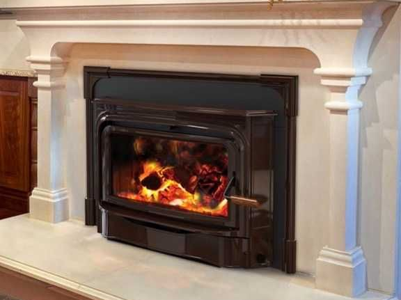 Black metal fireplace insert with a bright fire set into a cream stone mantel