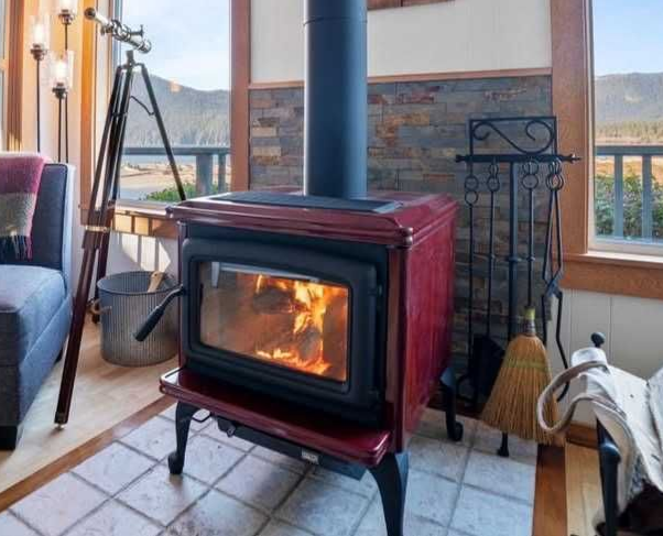 Modern fireplace with a bright fire in a white brick wall, framed in dark trim