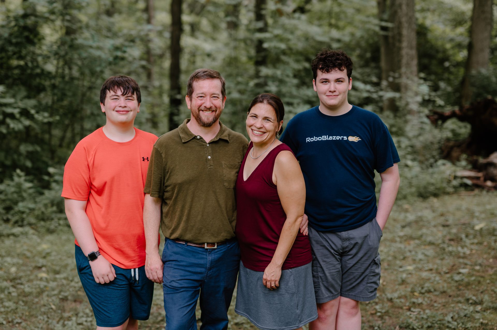 Michael Lawyer with his wife and two sons in a wooded area.
