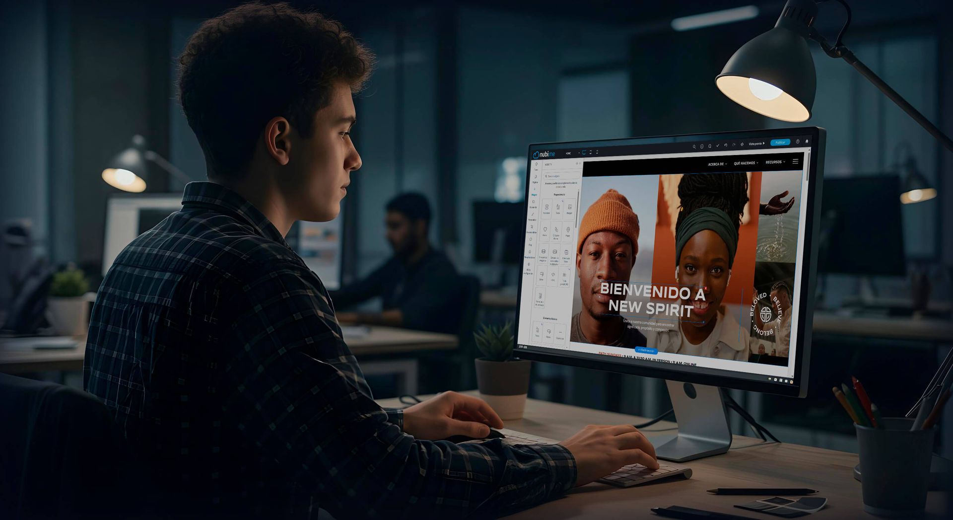 Persona joven frente a una computadora, diseñando gráficos con fotos de personas que usan sombreros en una oficina.
