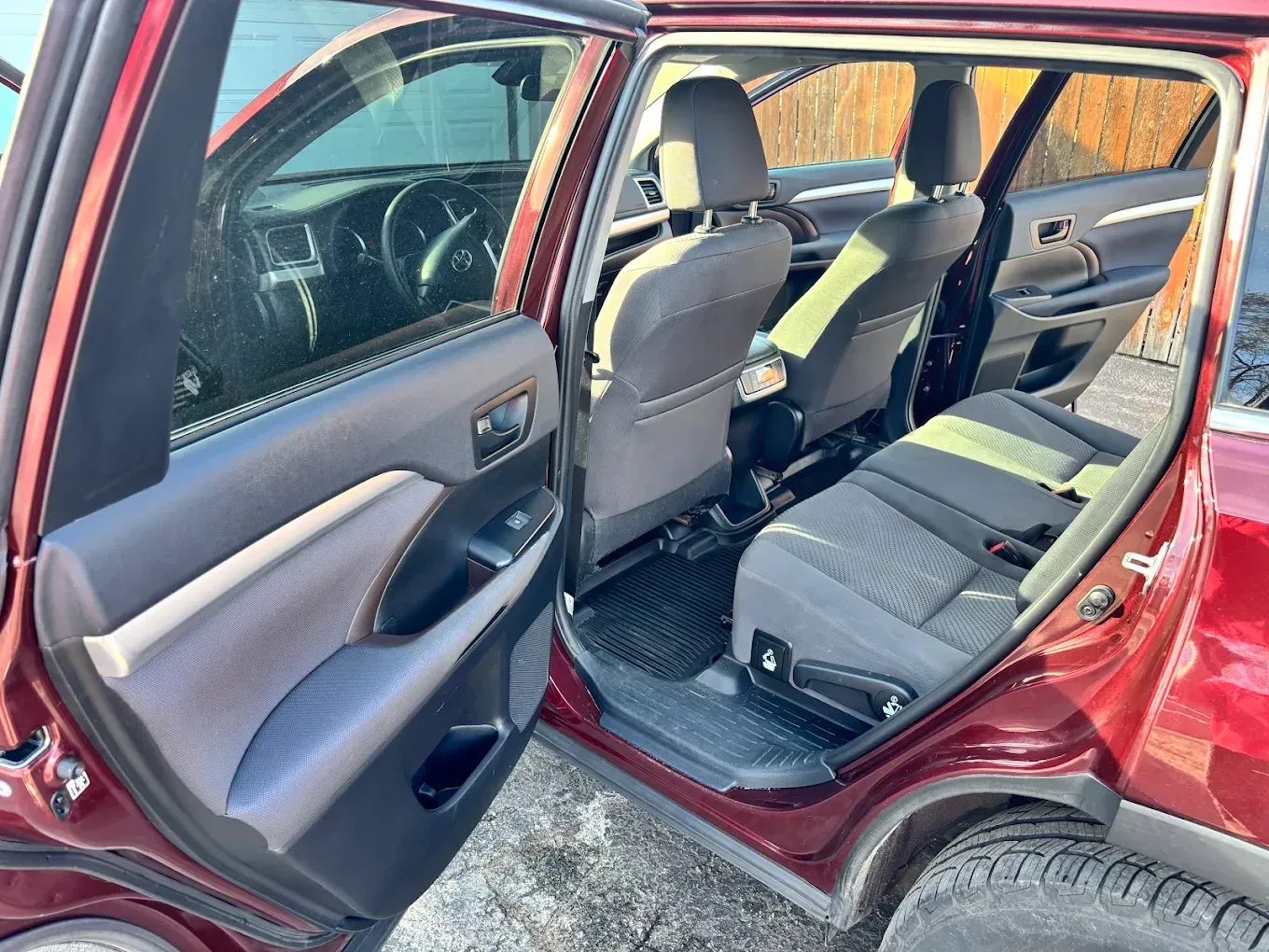 Rear door open on red car, showing gray back seat and interior from the side