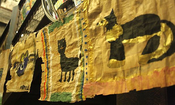 Handbemalte Textilbanner mit schwarzer Katze und abstrakten Formen in Braun- und Goldtönen.
