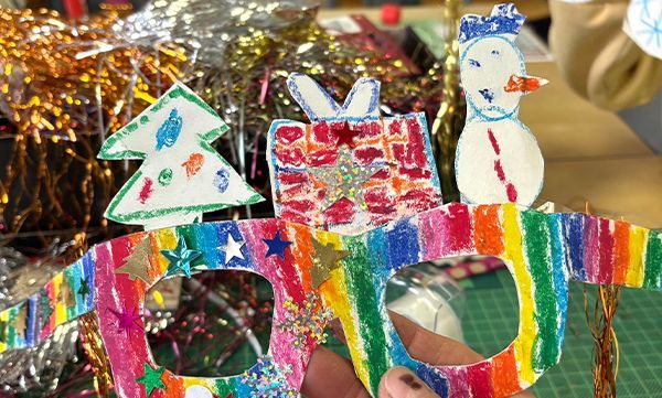 Bunte, handgefertigte Weihnachtsgläser mit Dekorationen: Weihnachtsbaum, Geschenk, Schneemann und Regenbogenstreifen.