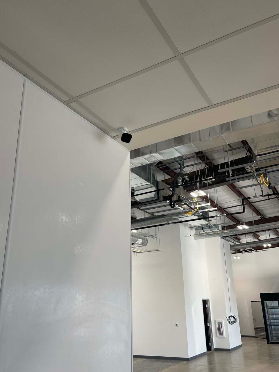 There is a camera on the ceiling of a building.