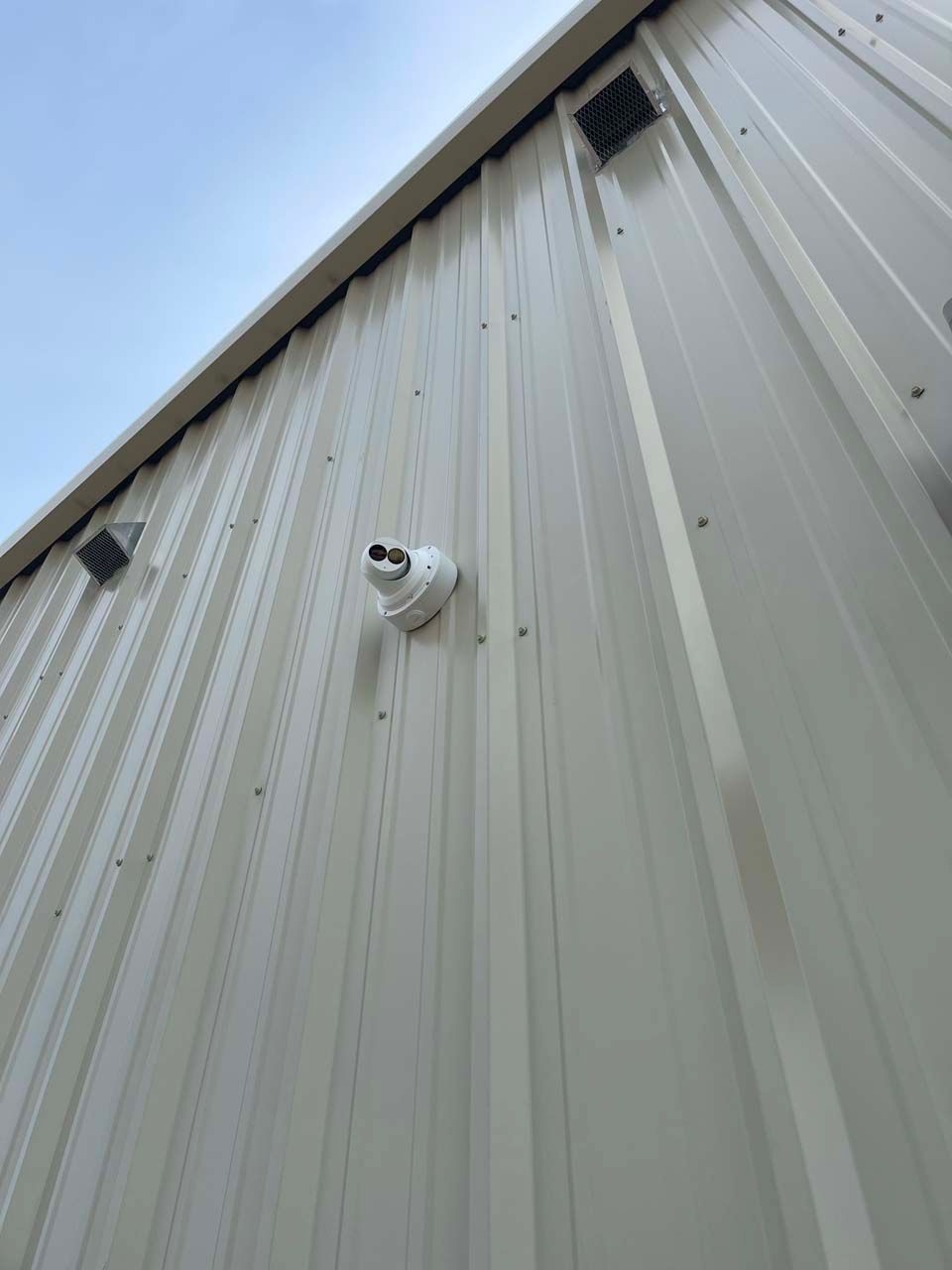 A security camera is mounted on the side of a building.