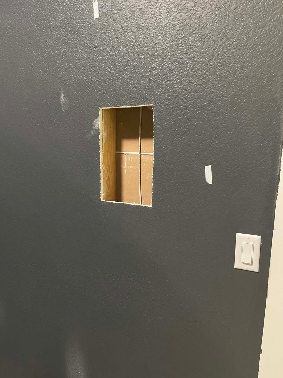 There is a hole in the wall that looks like a window.