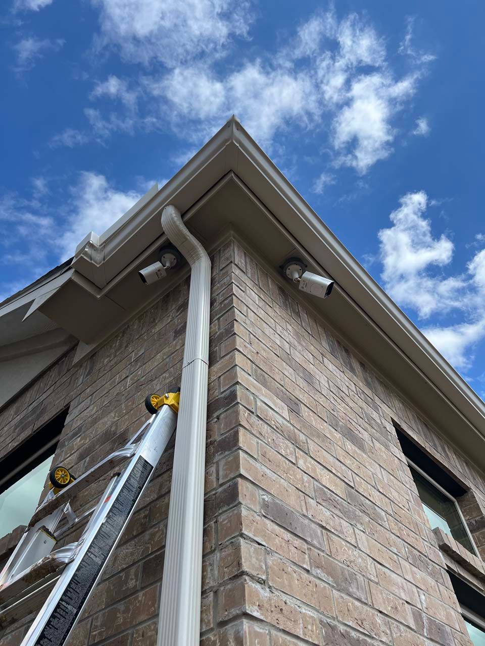A ladder is attached to the side of a brick building.
