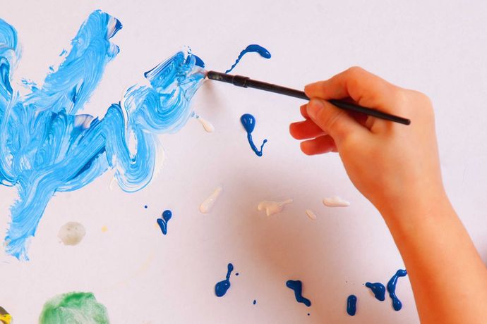 Peinture bleue à la main sur du papier blanc avec un petit pinceau