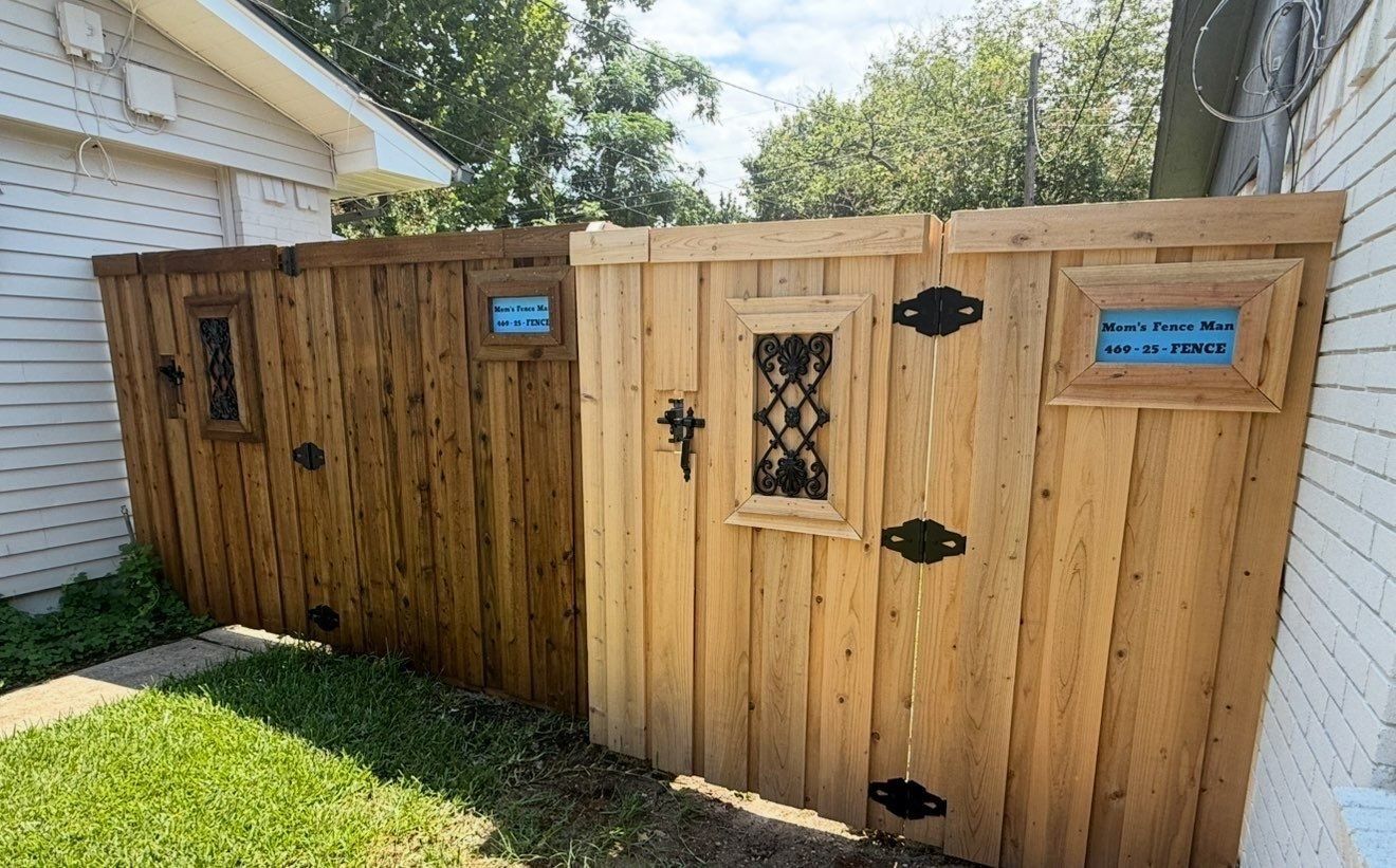 Wooden backyard enclosure with gates and signs beside a house on a sunny lawn