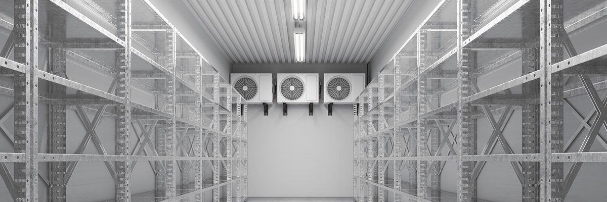 An empty warehouse storage room with metal shelves and refrigeration units.