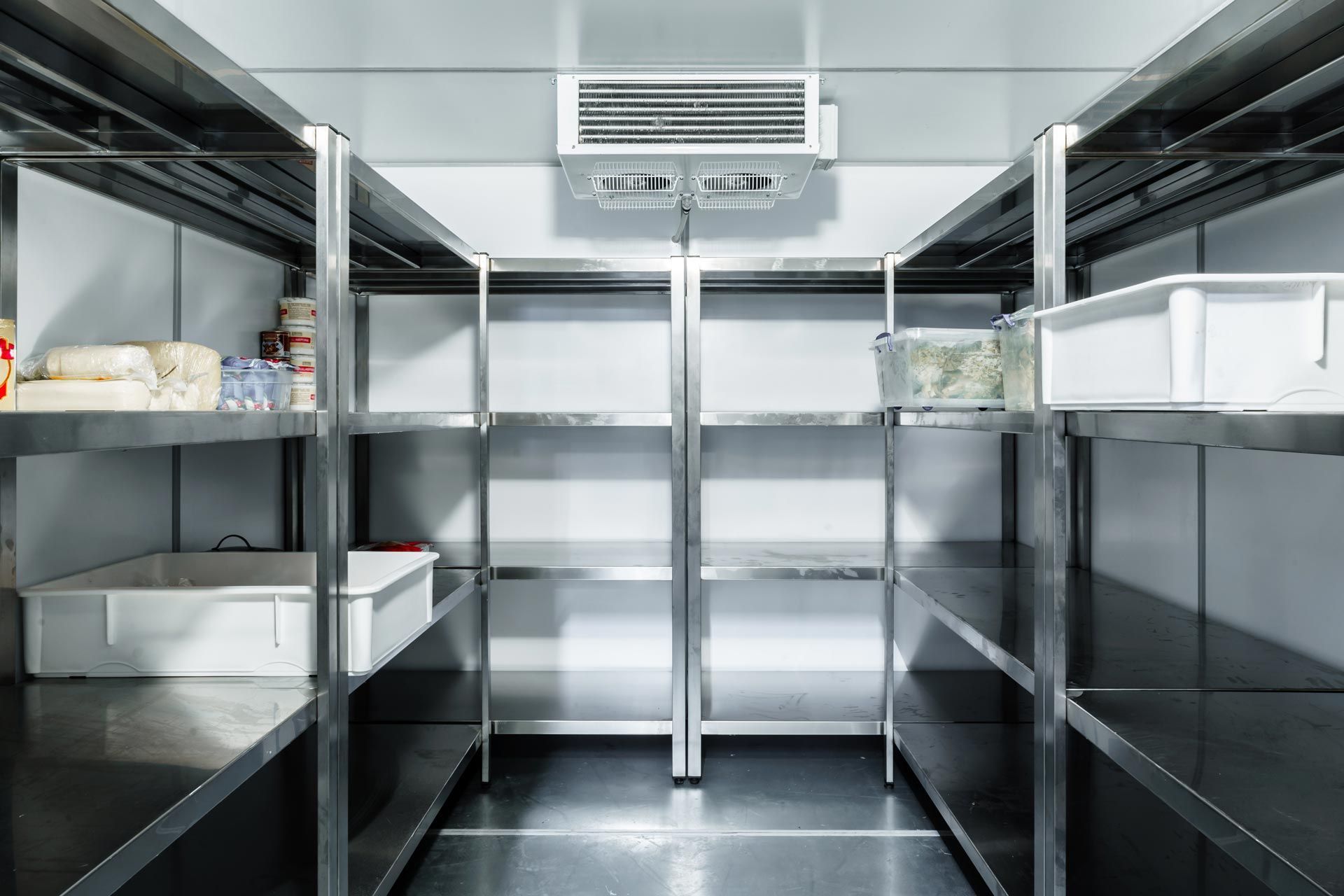 A cool room chamber with steel shelves holding plastic containers