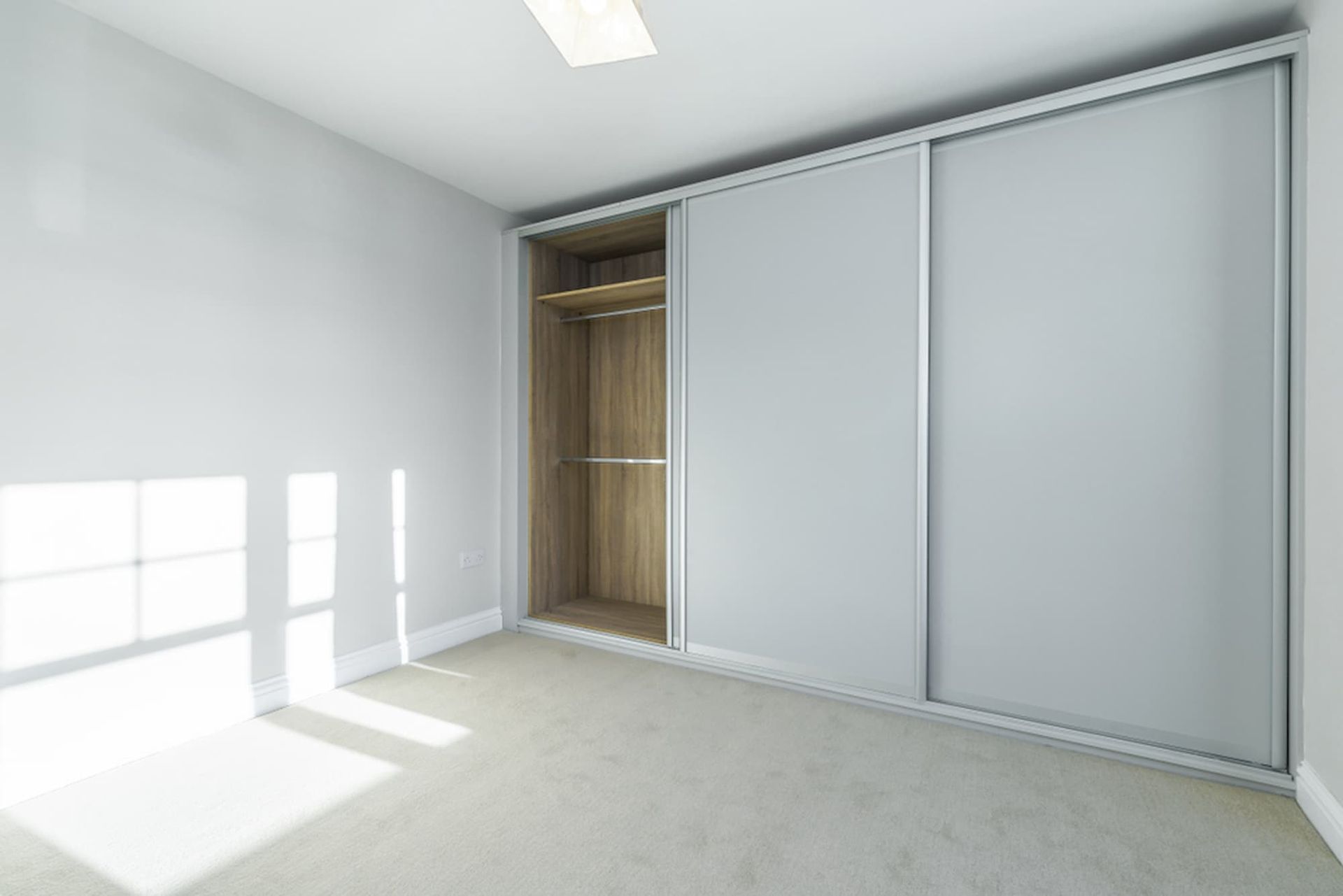 An Empty Bedroom with A Large Sliding Wardrobe and A Window — A Brush With Colour in Urraween, QLD