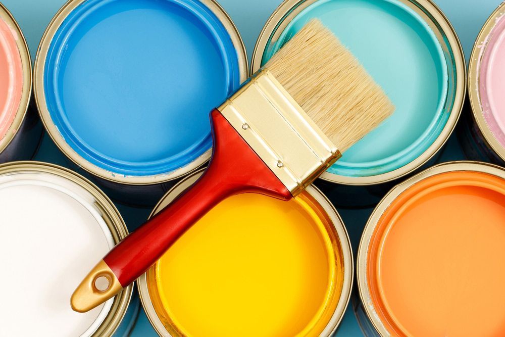 A Paint Brush Is Sitting on Top of A Row of Paint Cans — A Brush With Colour in Craignish, QLD