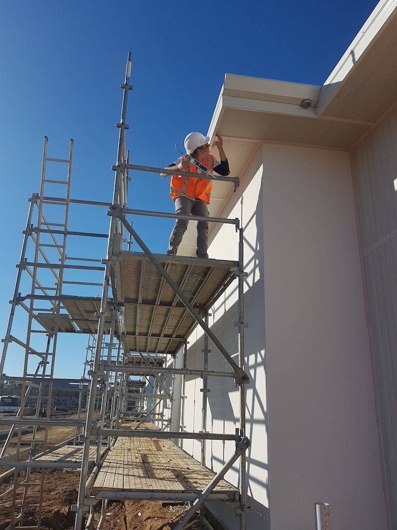 A Man Is Standing on A Ladder Painting a Door — A Brush With Colour in Wondunna, QLD