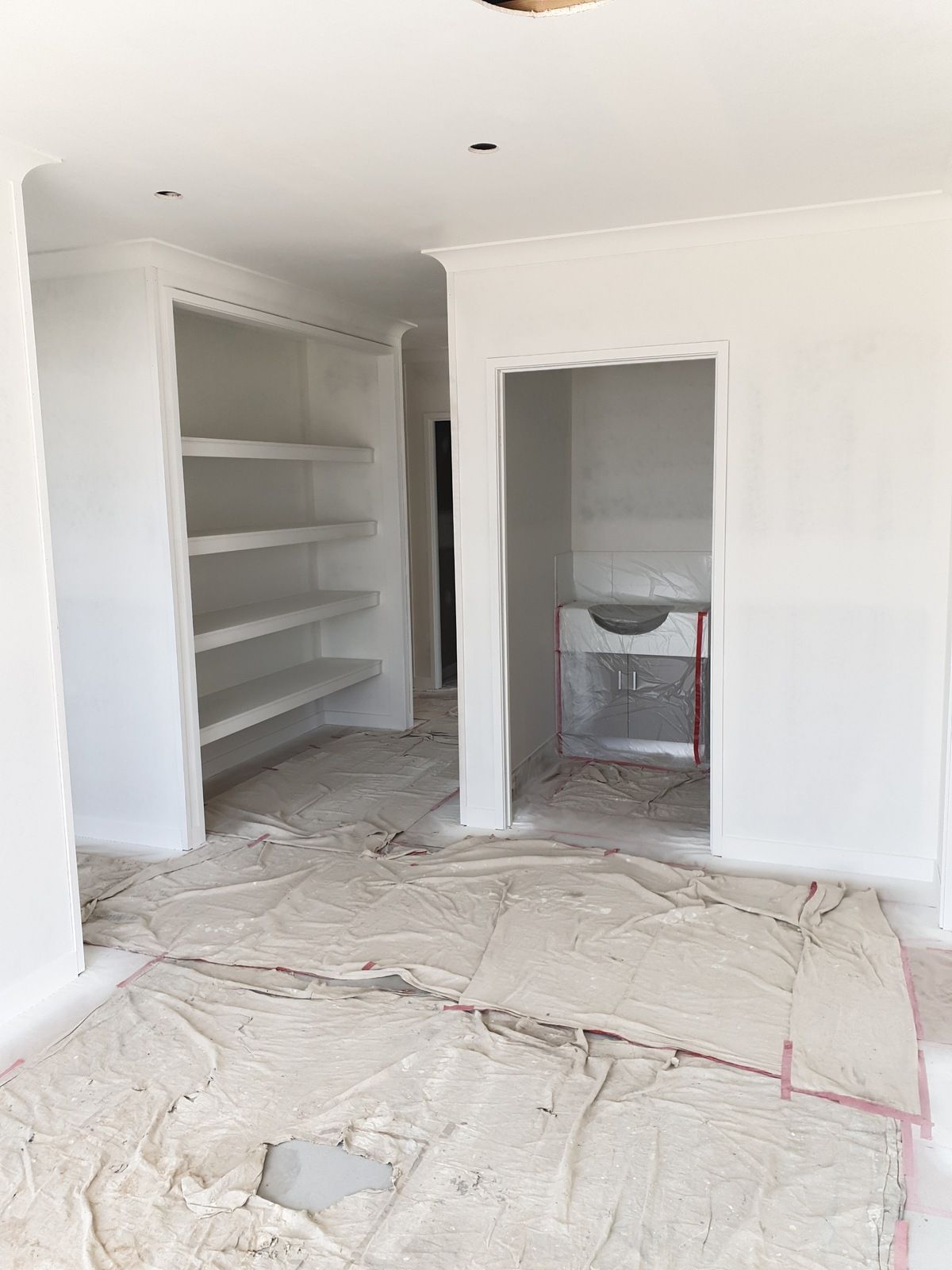 A Hallway with Wooden Floors, White Walls, and Brown Doors — A Brush With Colour in Pialba, QLD