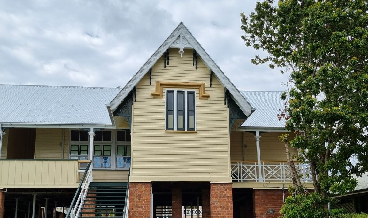 A Man Is Working on The Roof of A Building — A Brush With Colour in Craignish, QLD